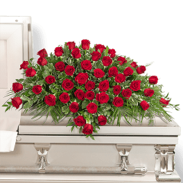 Red rose casket spray on a white casket