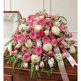 Pink and white floral casket spray with ribbon accents