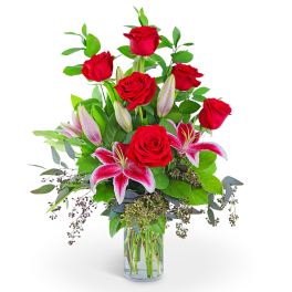 Red roses and pink lilies in a clear glass vase