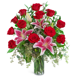 Red roses and pink lilies in a clear glass vase
