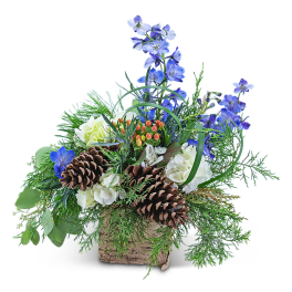 Blue flowers and white blooms in a rustic basket with pinecones