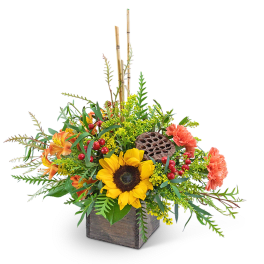 Sunflower arrangement in a wooden box with orange blooms and berries