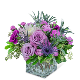 Lavender roses and purple flowers in a clear glass vase