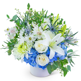White lilies and roses with blue hydrangeas in a white vase