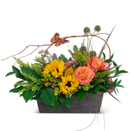 Sunflowers and orange roses in a rectangular basket with a butterfly pick