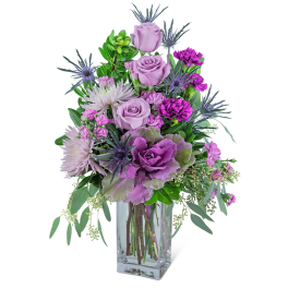 Lavender roses and purple flowers in a clear glass vase