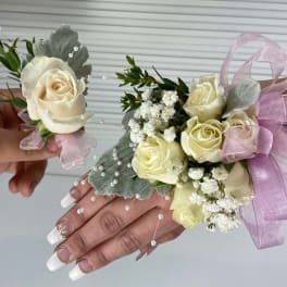 Cream rose corsage and boutonniere with pink ribbon