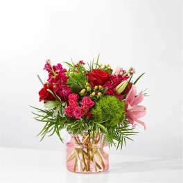 Pink and red flower bouquet in a pink glass vase