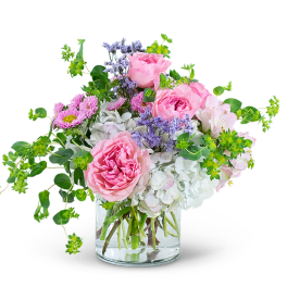 Pink roses and mixed flowers in a clear glass vase