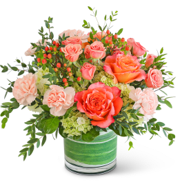 Coral roses and pale carnations in a green-striped glass vase