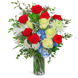 Bouquet of red and pale yellow roses with white lilies in a glass vase