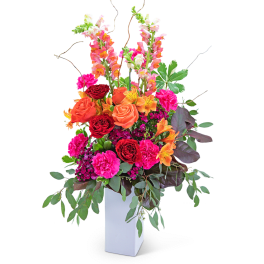Bright mixed flower arrangement in a white vase