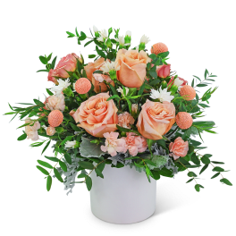 Peach roses and pink carnations in a white vase