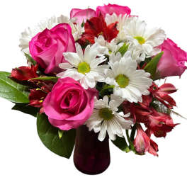 Pink roses and white daisies in a dark glass vase