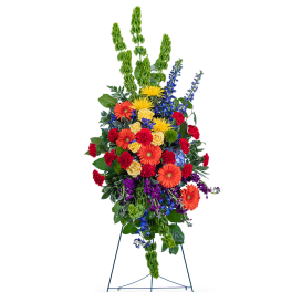 Tall standing floral spray with orange, yellow, red, and purple flowers