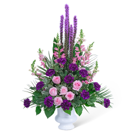 Pink roses and purple flowers arranged in a white vase