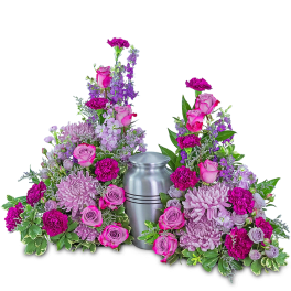 Two pink and purple floral sprays flank a silver urn
