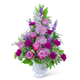 Pink and purple floral arrangement in a white vase