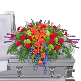 Colorful floral spray on a silver casket