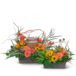 Two floral basket arrangements with orange roses and yellow sunflowers around a urn