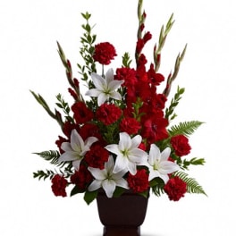 Red carnations and white lilies in a dark vase
