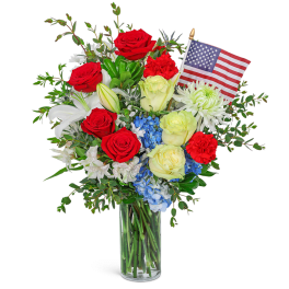 Bouquet of red, white, and blue flowers in a glass vase with a small American flag