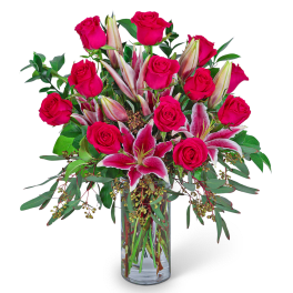 Pink roses and stargazer lilies in a clear glass vase