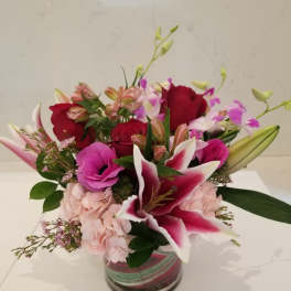 Mixed pink and red bouquet in a clear glass vase