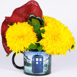 Yellow flowers arranged in a mug with a red mesh wrap