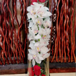 Tall glass vase with white orchids and red roses