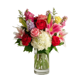 Mixed bouquet of roses, lilies, and hydrangea in a clear glass vase