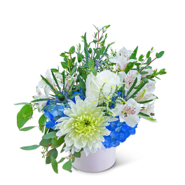 White and blue floral arrangement in a white container
