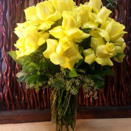 Yellow roses arranged in a clear glass vase