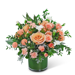 Peach roses and white flowers in a green glass vase