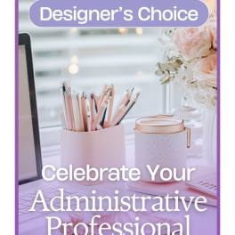 Desk scene with a pencil cup, mug, and pink flowers beside a monitor