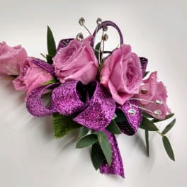 Pink rose corsage with purple ribbon and jeweled accents