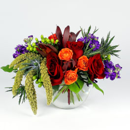 Bouquet of red and orange roses in a clear glass vase
