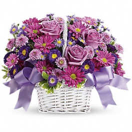 Lavender roses and purple daisies in a white basket with purple bows