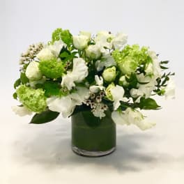 White floral arrangement in a green glass vase