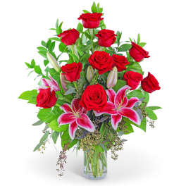 Red roses and pink lilies in a clear glass vase