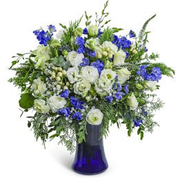 White and blue floral arrangement in a cobalt glass vase