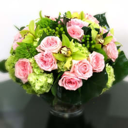 Pink roses and green orchids in a glass vase