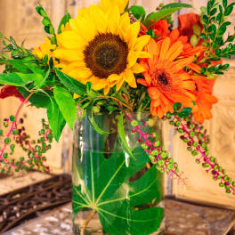 Sunflowers and orange gerbera daisies in a glass vase