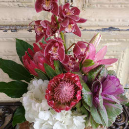 Pink orchids and mixed blooms arranged in a compact bouquet