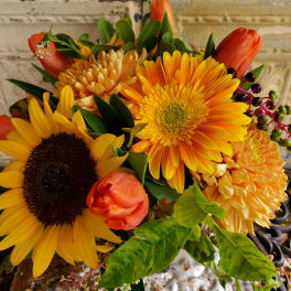 Bouquet of yellow sunflowers, orange tulips, and orange mums