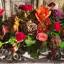 Mixed bouquet with orange, pink, and red flowers and greenery
