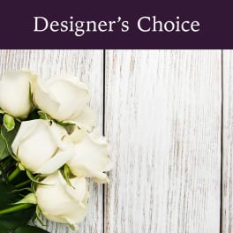 White roses on a rustic wood background with "Designer’s Choice" text