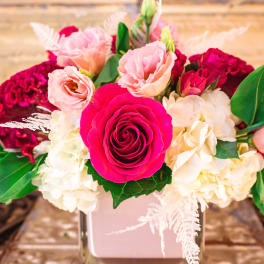 Pink and white floral arrangement in a square vase