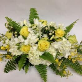 Yellow and white floral arrangement with fern fronds