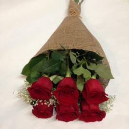 Bouquet of red roses wrapped in burlap with baby's breath